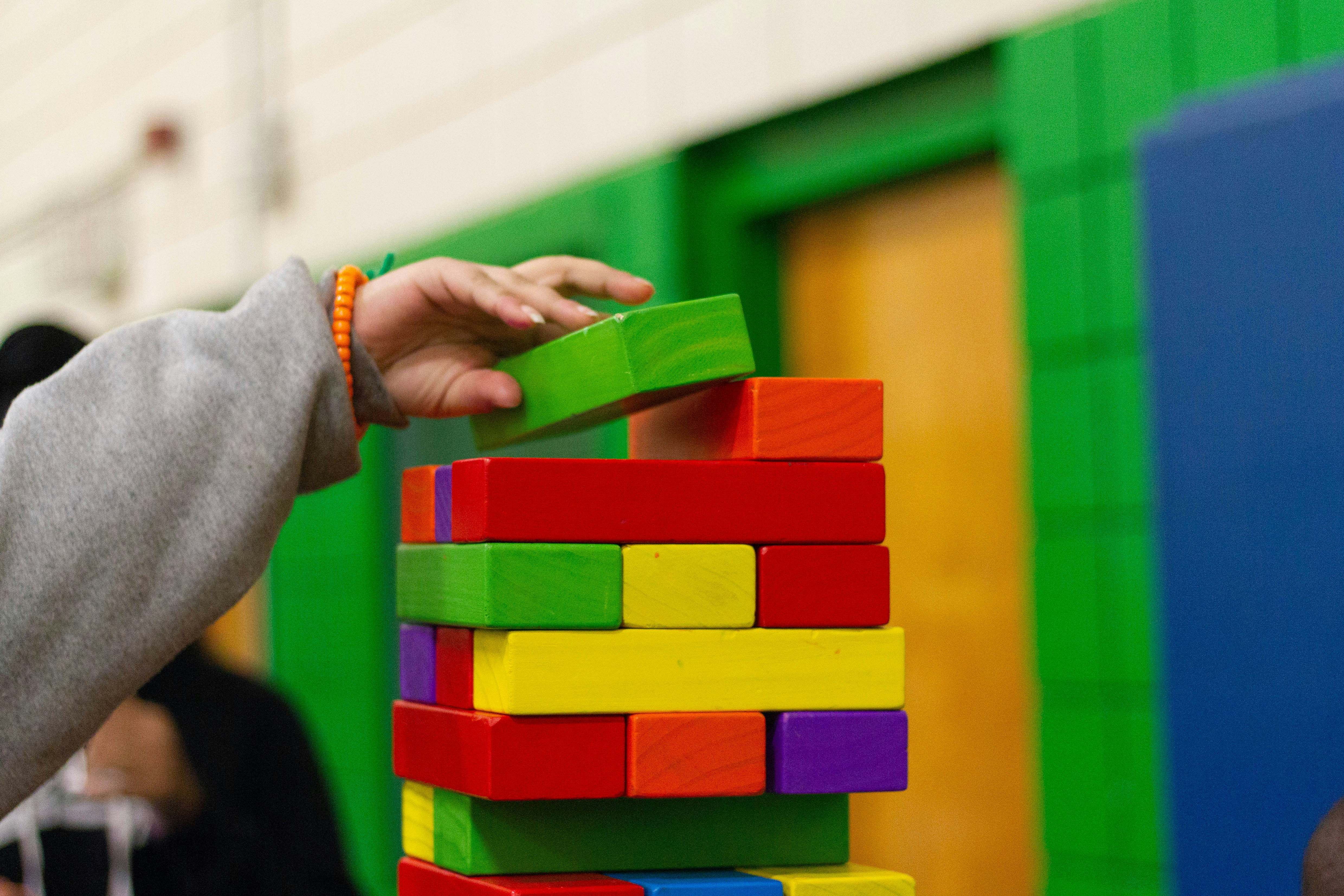 Colorful building blocks stacked by hand