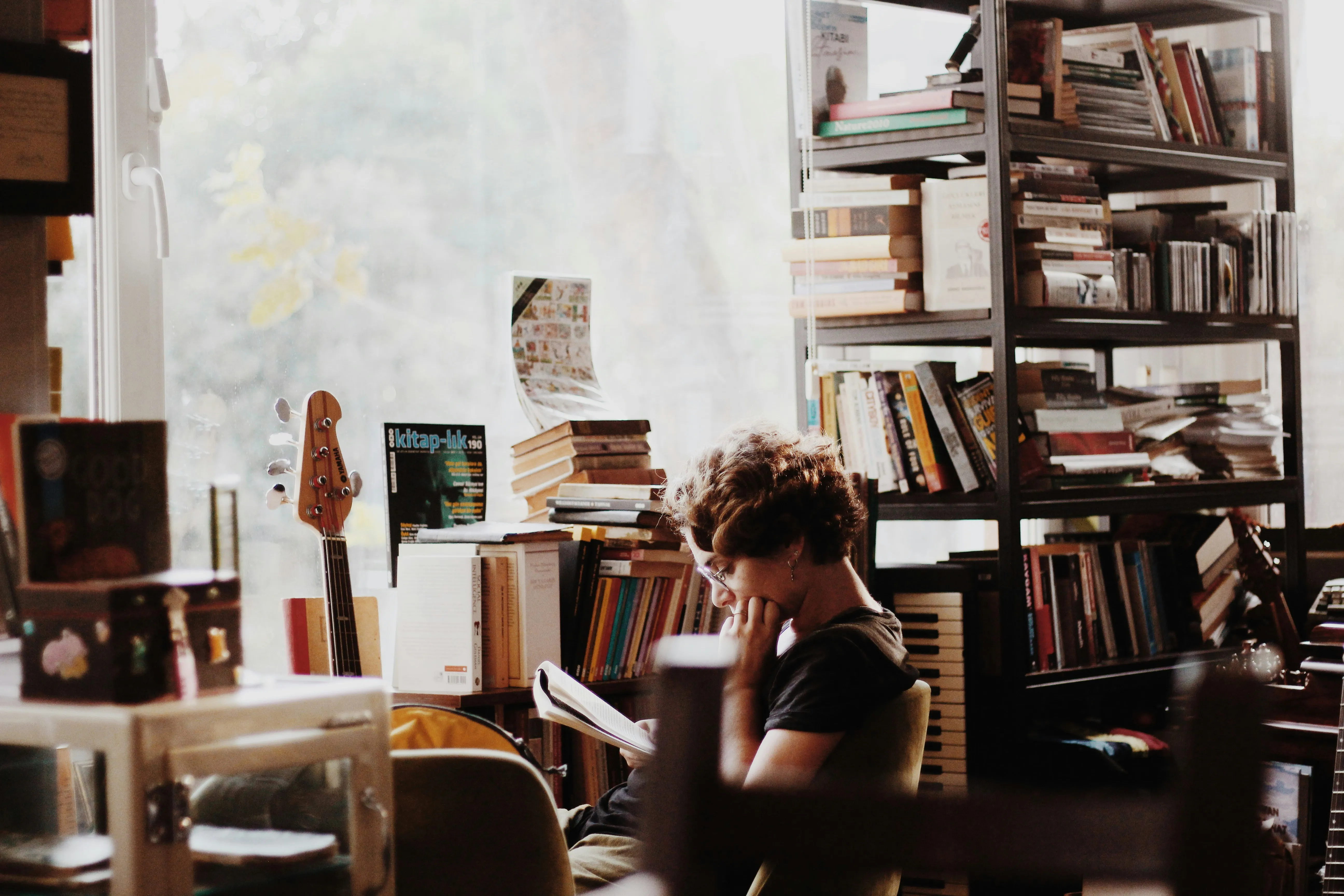Person reading surrounded by books and documents