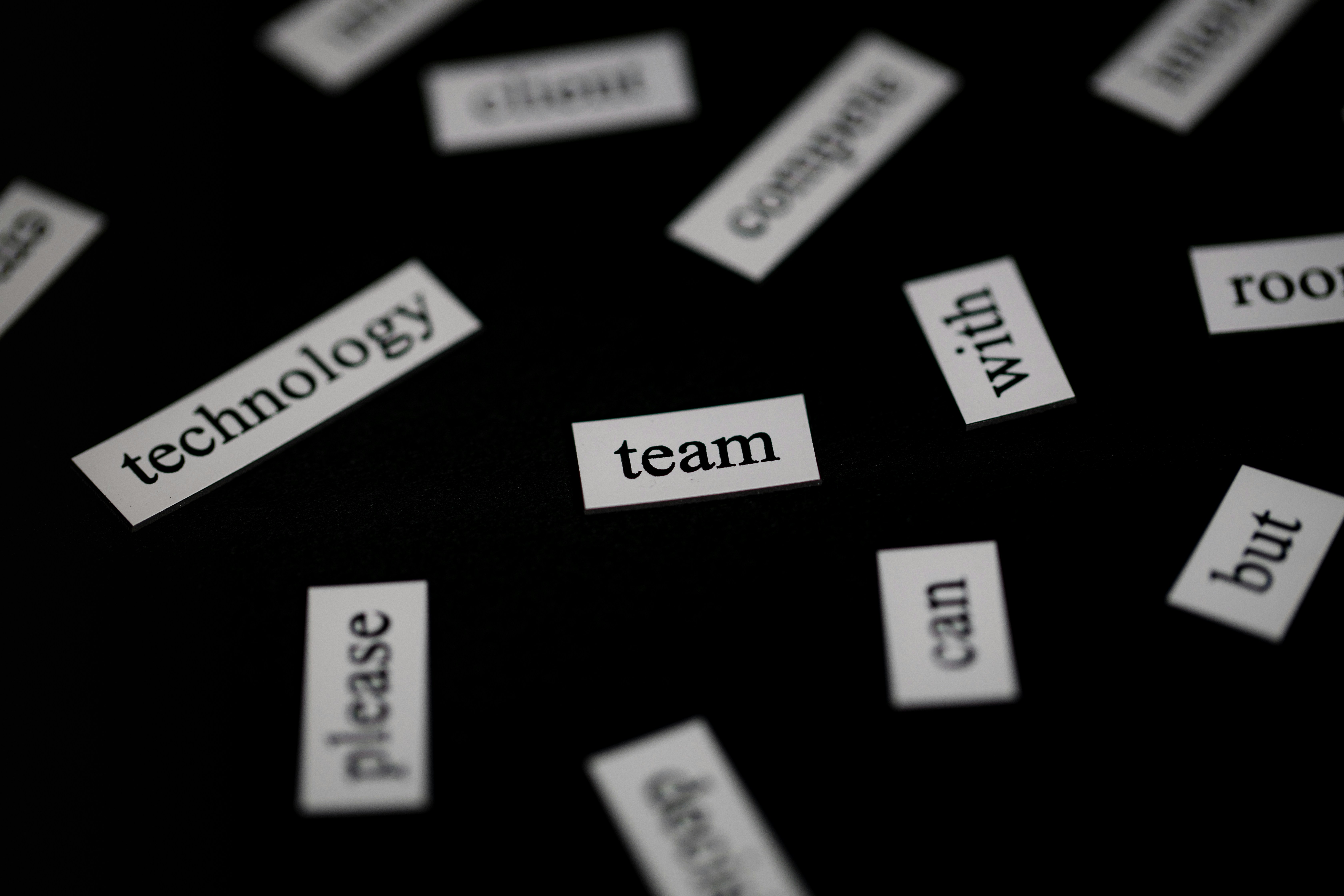 Word tiles scattered on a black surface